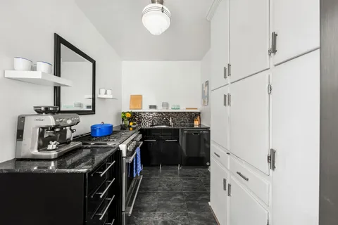 a kitchen with a stove top oven and cabinets