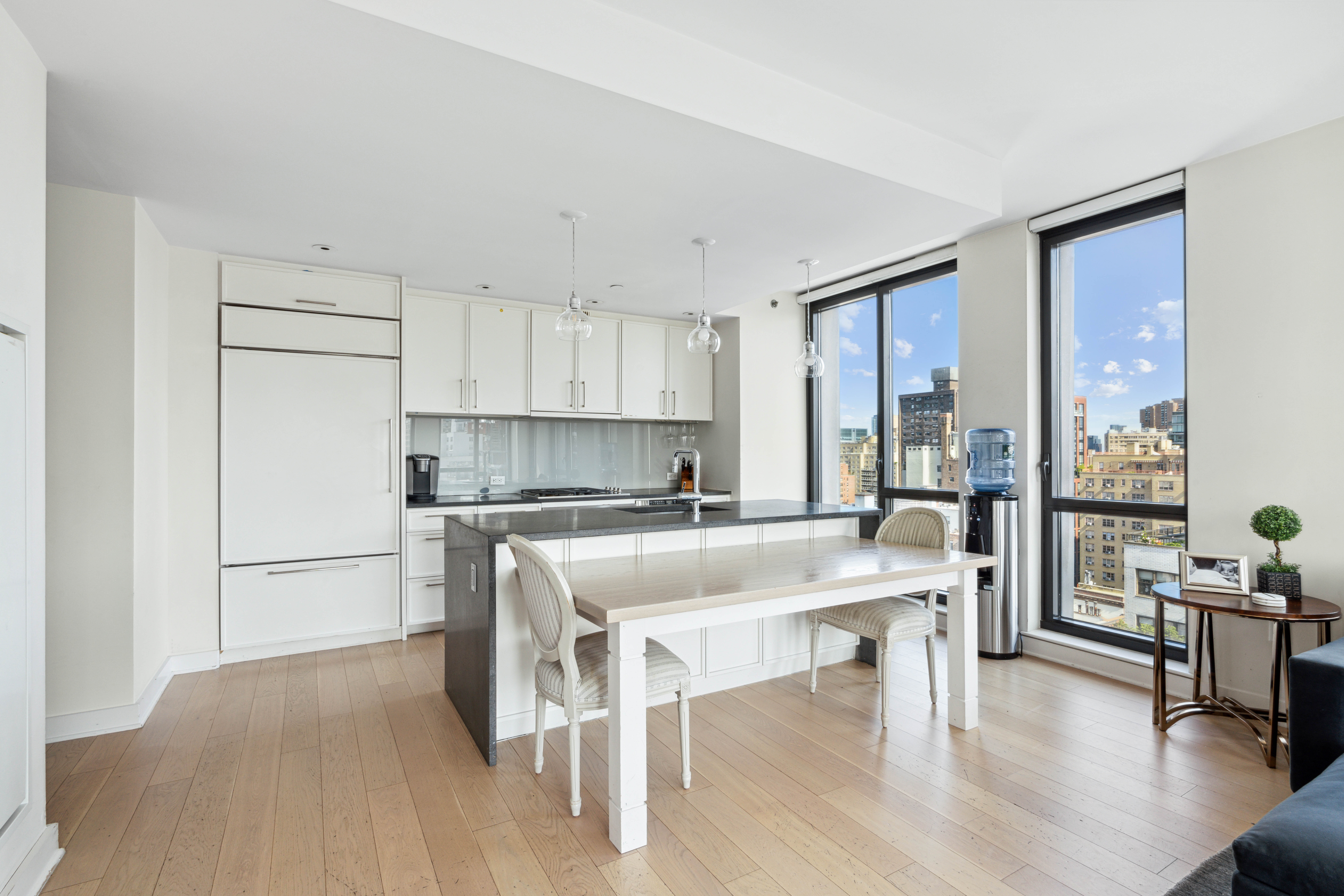 160 East 22nd Street, Unit 18C Manhattan, NY 10010 - Photo 5 of 12 a kitchen with a table chairs refrigerator and cabinets