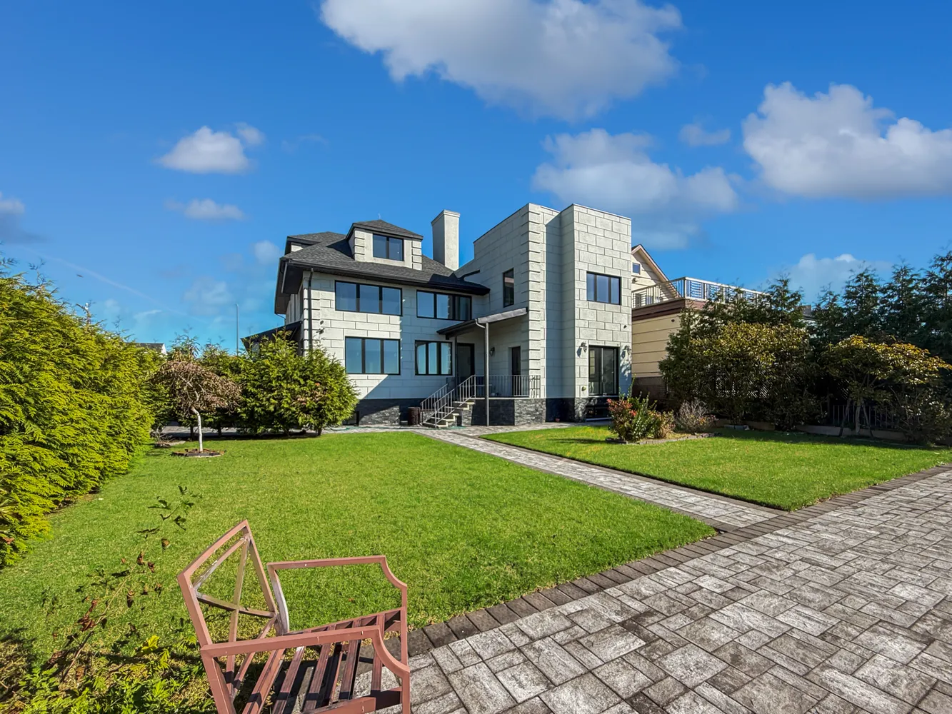 a view of a house with a big yard plants and large trees