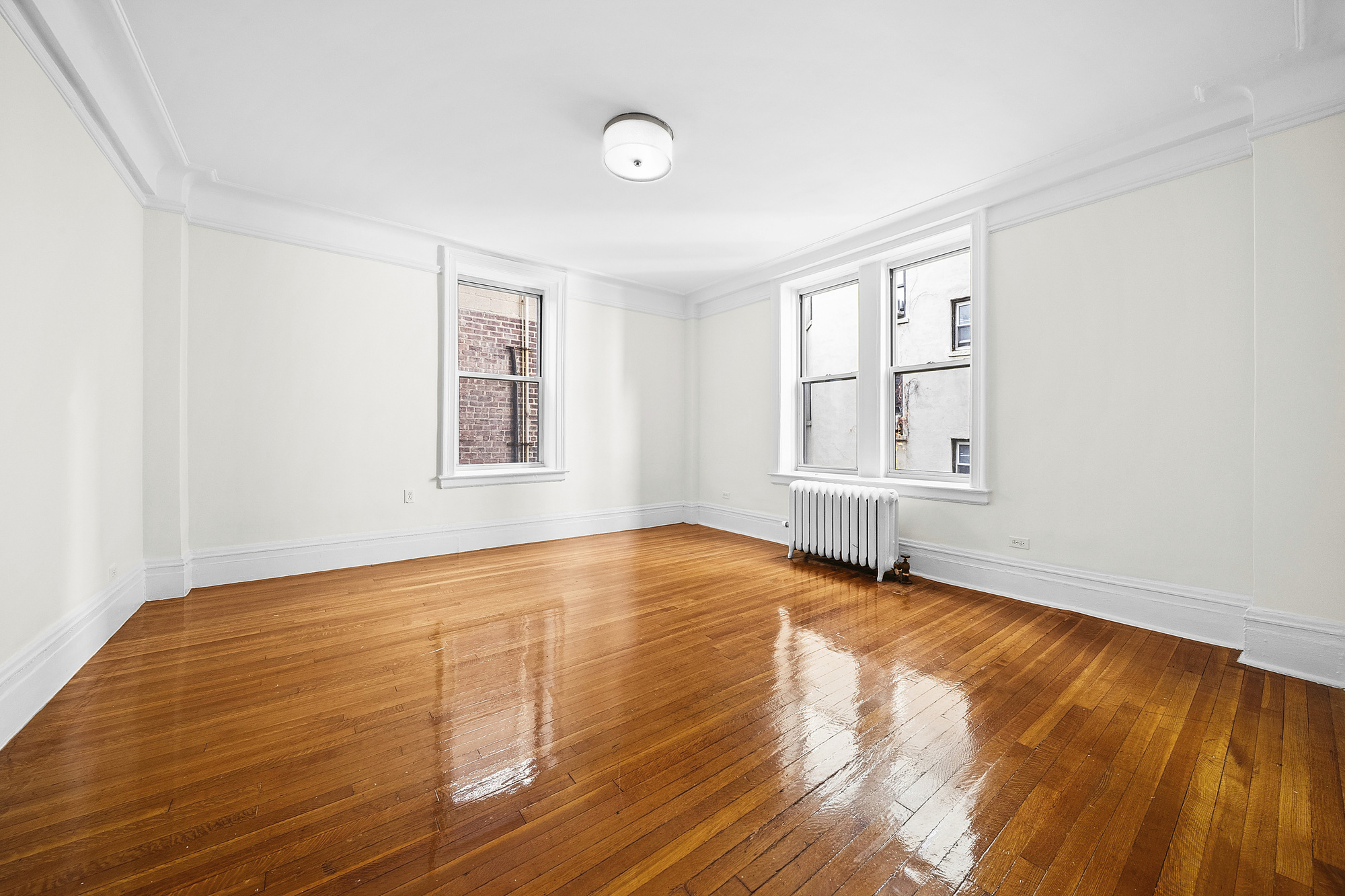123 Waverly Place, Unit 2D Manhattan, NY 10011 - Photo 1 of 6 a view of an empty room with wooden floor and windows