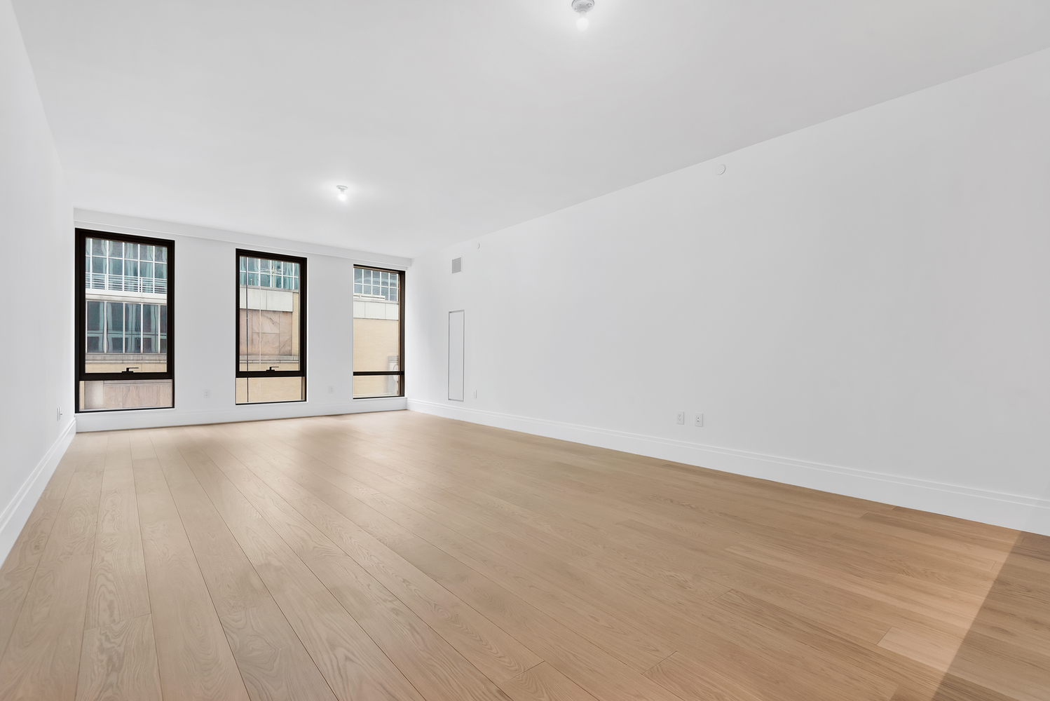 50 West 66th Street, Unit 7B Manhattan, NY 10023 - Photo 2 of 24 a view of an empty room with wooden floor and windows