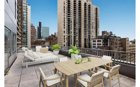 a view of roof with potted plants and city view