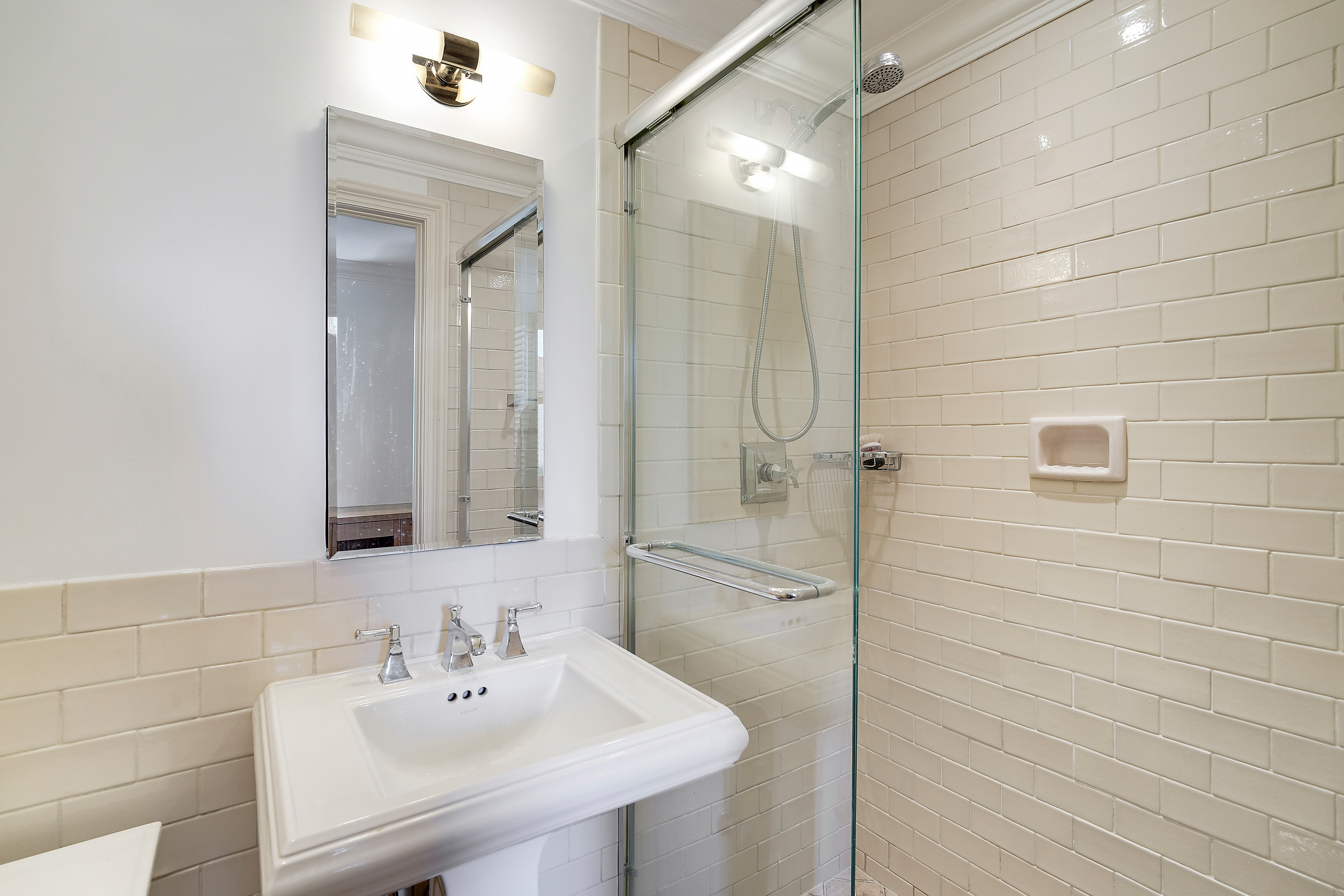 175 East 62nd Street, Unit 8D Manhattan, NY 10065 - Photo 19 of 24 a bathroom with a sink shower and a mirror