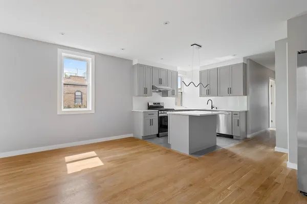a kitchen with a sink cabinets and wooden floor
