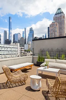 a view of a roof deck with couches and wooden floor