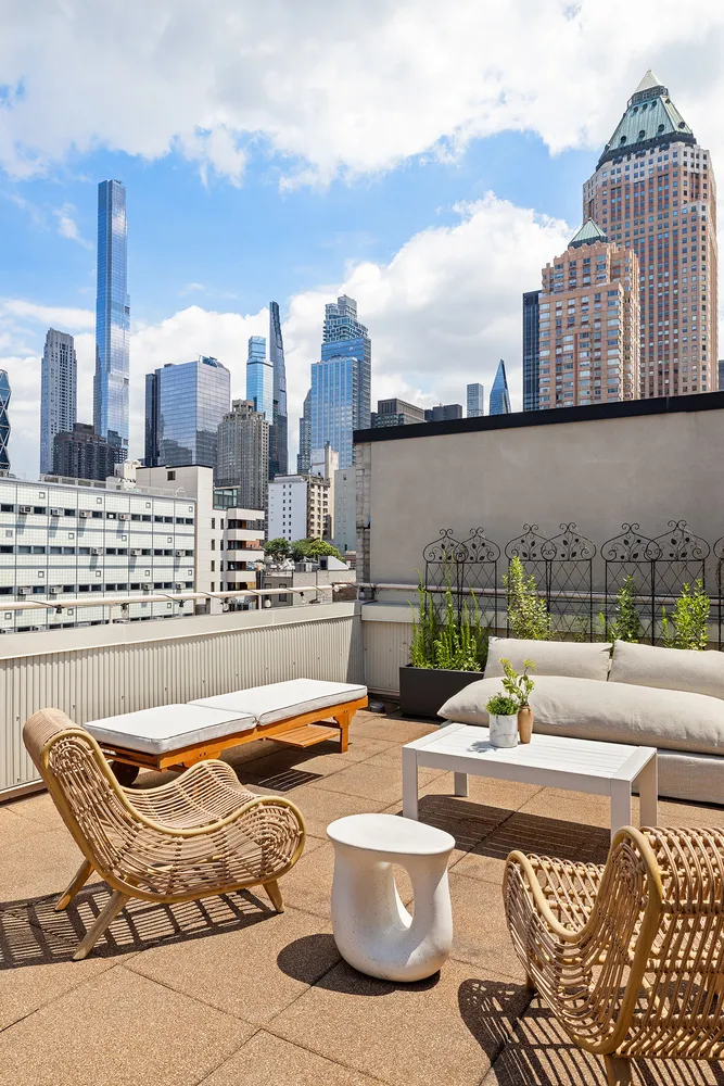a view of a roof deck with couches and wooden floor