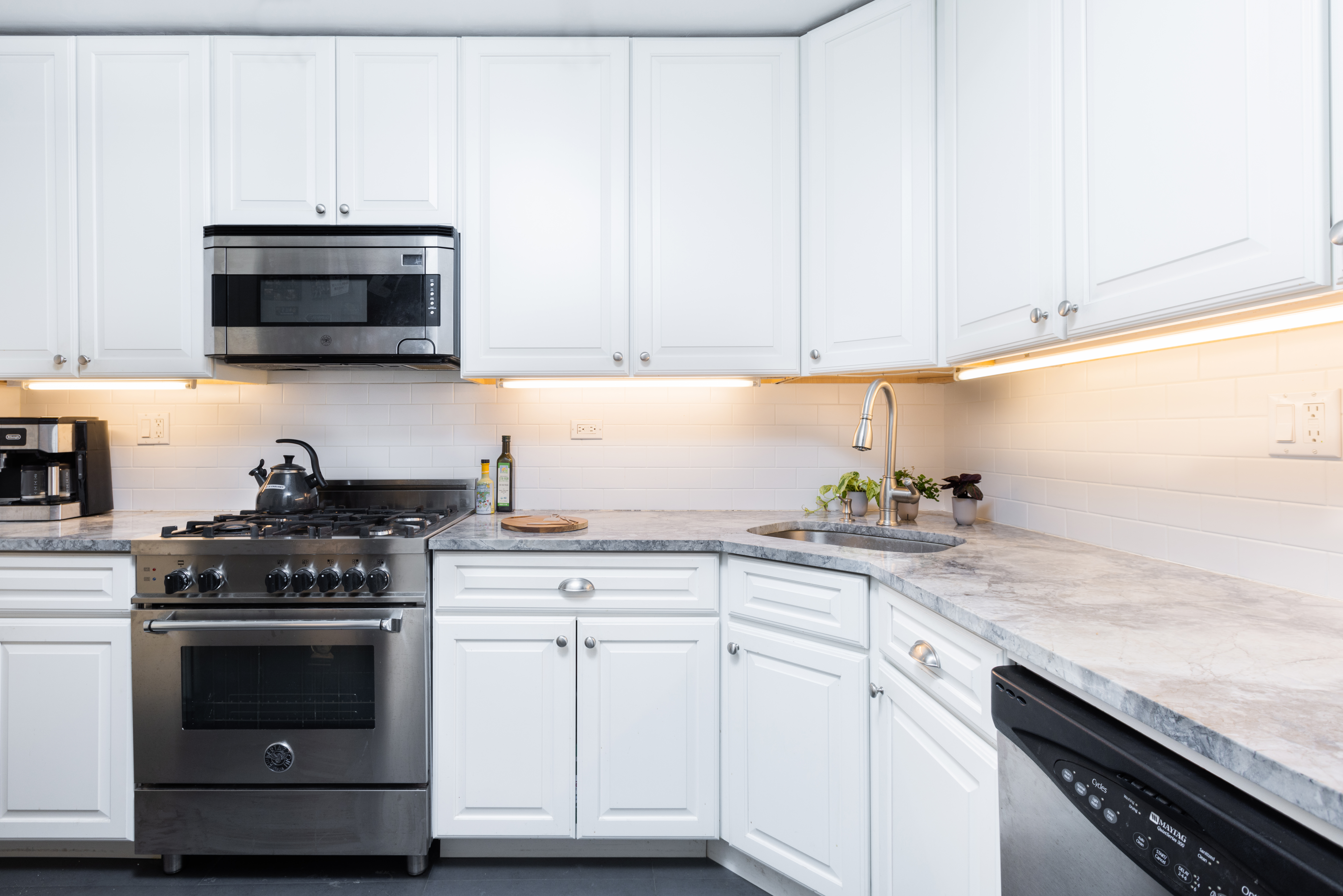 245 East 25th Street, Unit 19L Manhattan, NY 10010 - Photo 6 of 13 a kitchen with granite countertop white cabinets and stainless steel appliances
