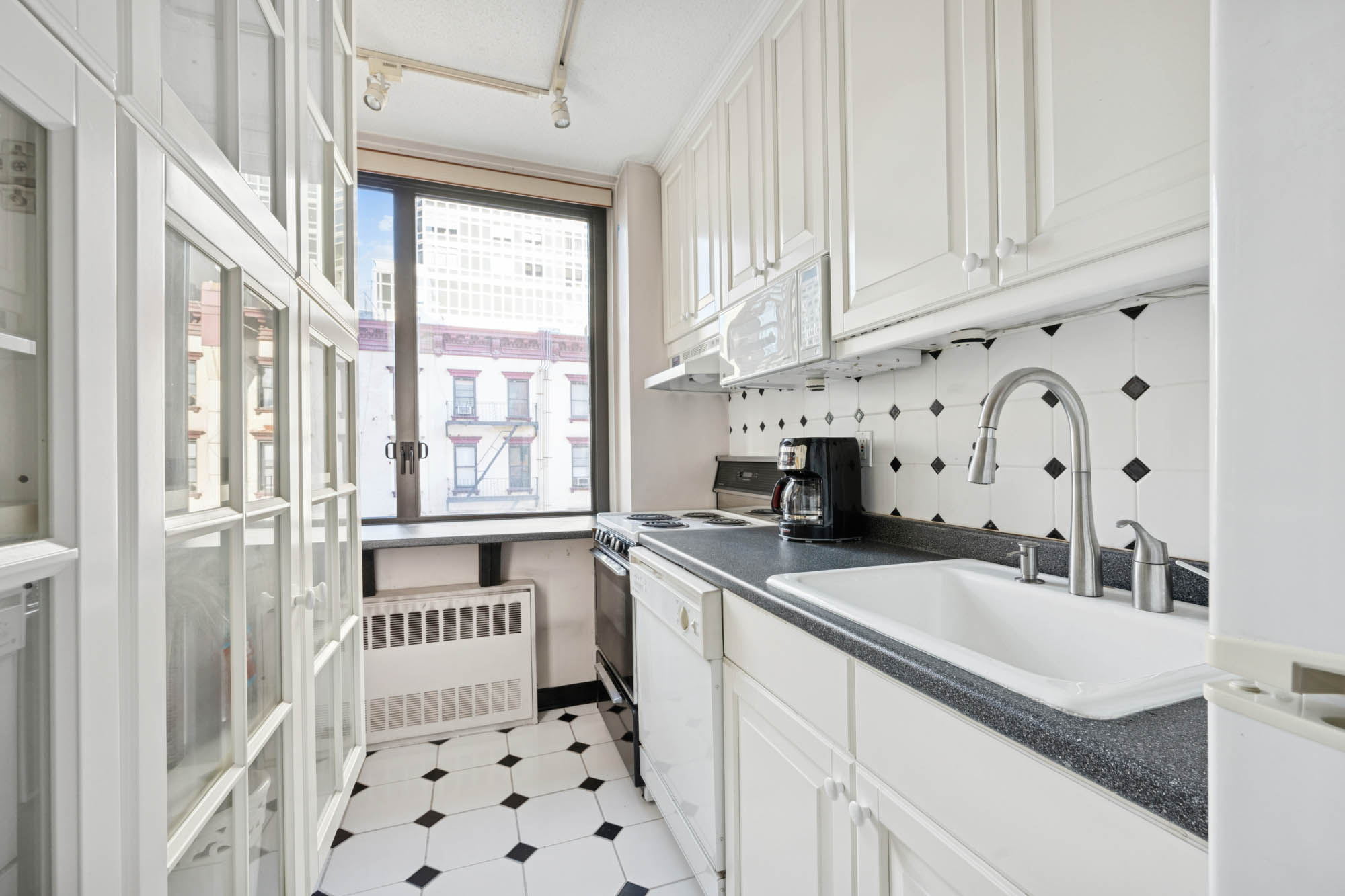 300 East 54th Street, Unit 3H Manhattan, NY 10022 - Photo 5 of 10 a kitchen with a sink stove and cabinets
