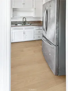 a kitchen with stainless steel appliances white cabinets and a refrigerator