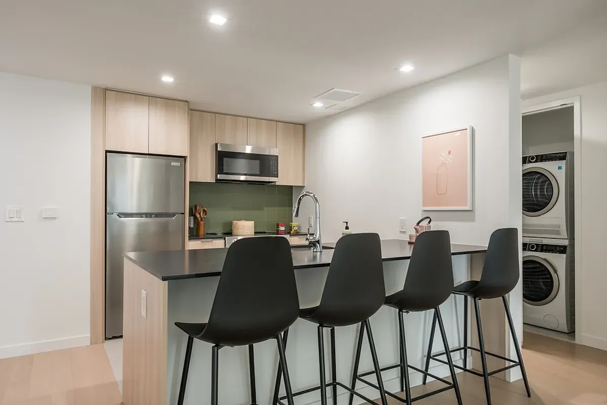 a kitchen with stainless steel appliances granite countertop a refrigerator and a stove top oven