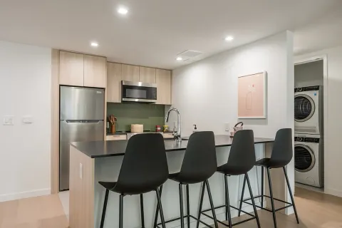 a kitchen with stainless steel appliances granite countertop a refrigerator and a stove top oven