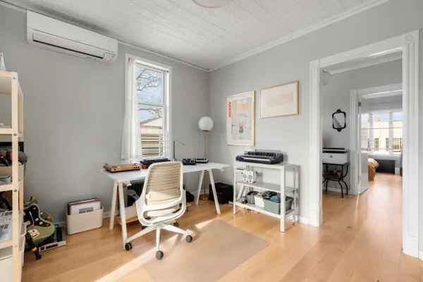 a living room with furniture a wooden floor and a large window