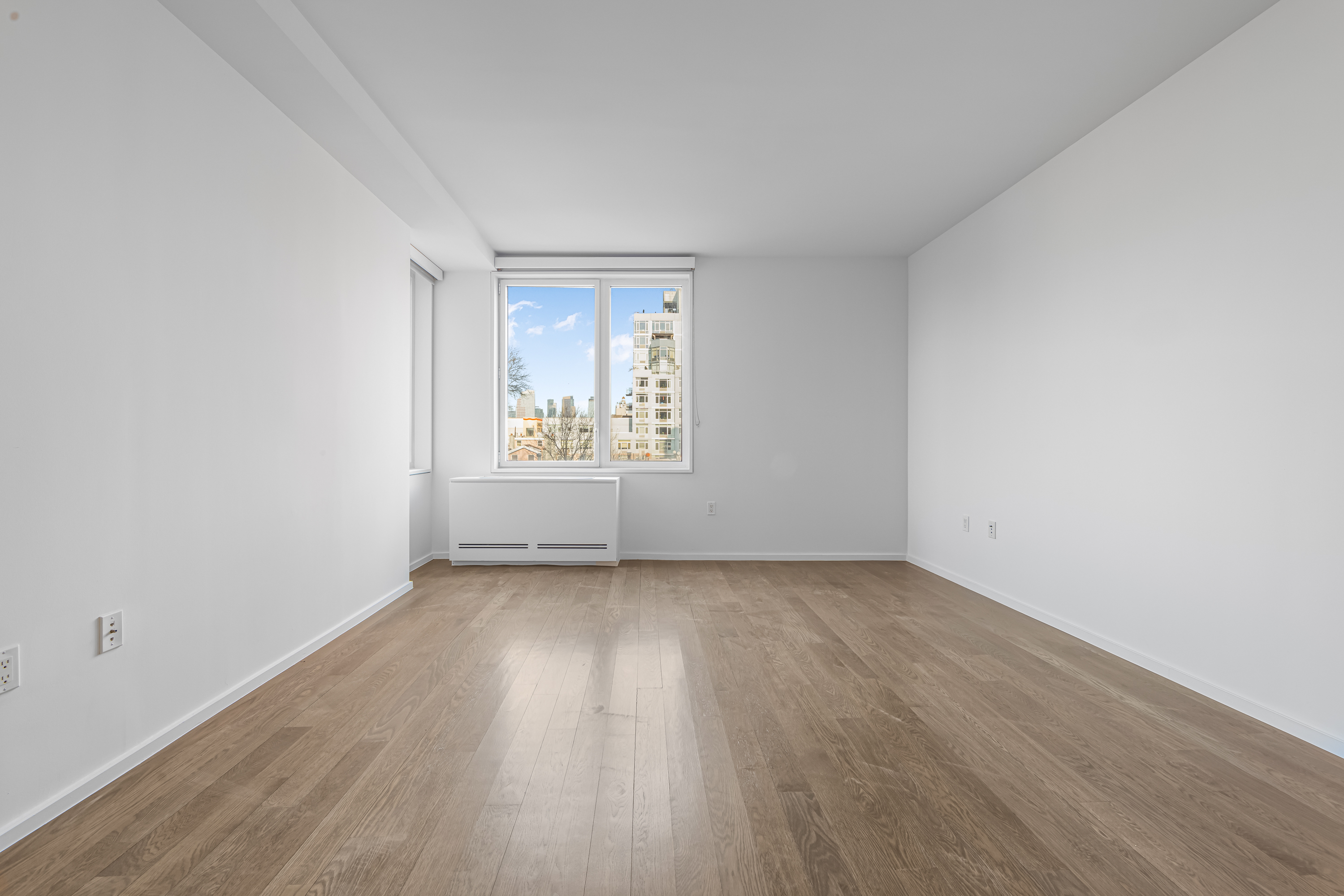 202 8th Street, Unit 4E Brooklyn, NY 11215 - Photo 5 of 19 an empty room with wooden floor and windows