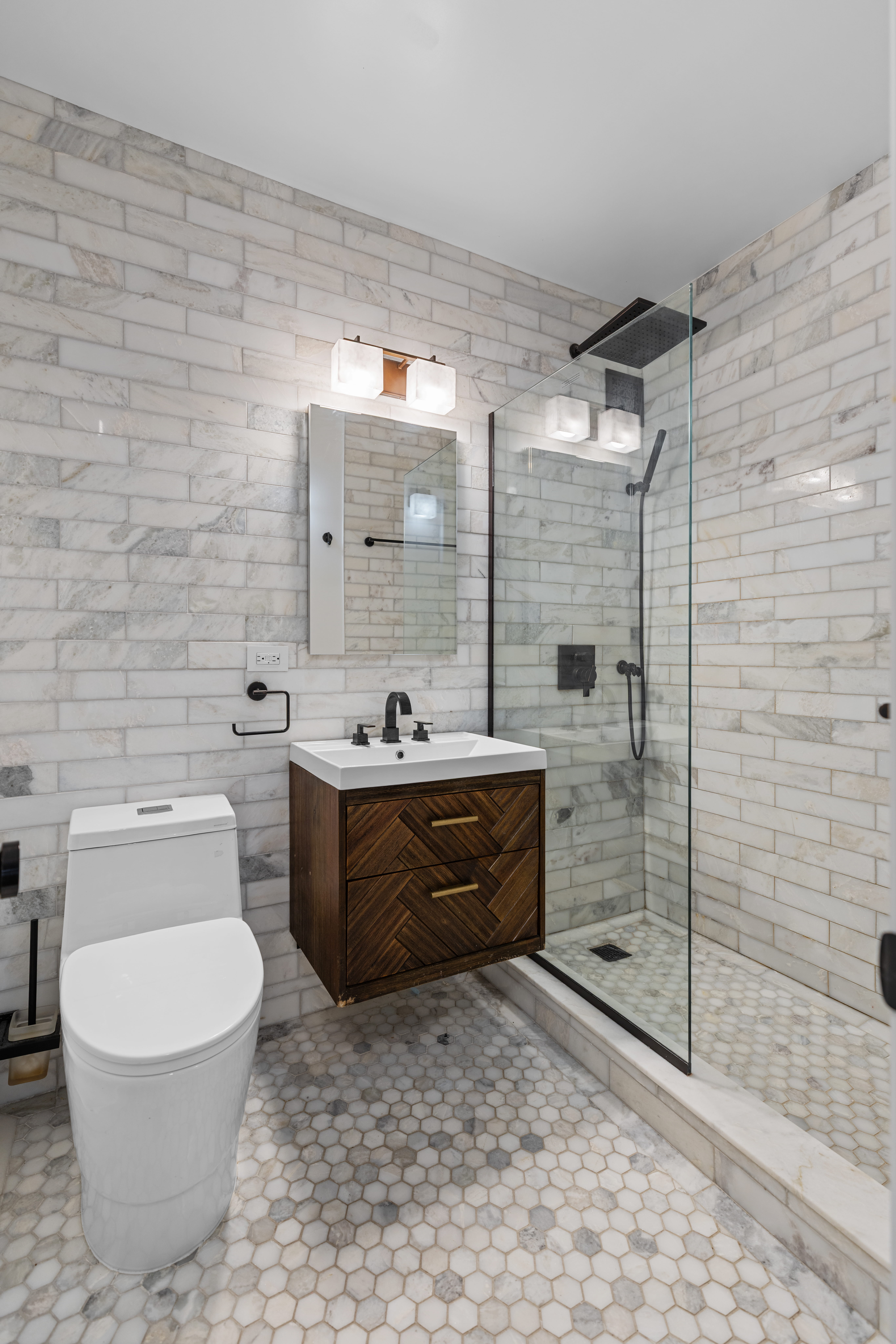 159 West 53rd Street, Unit 31F Manhattan, NY 10019 - Photo 6 of 16 a bathroom with a sink a toilet and shower