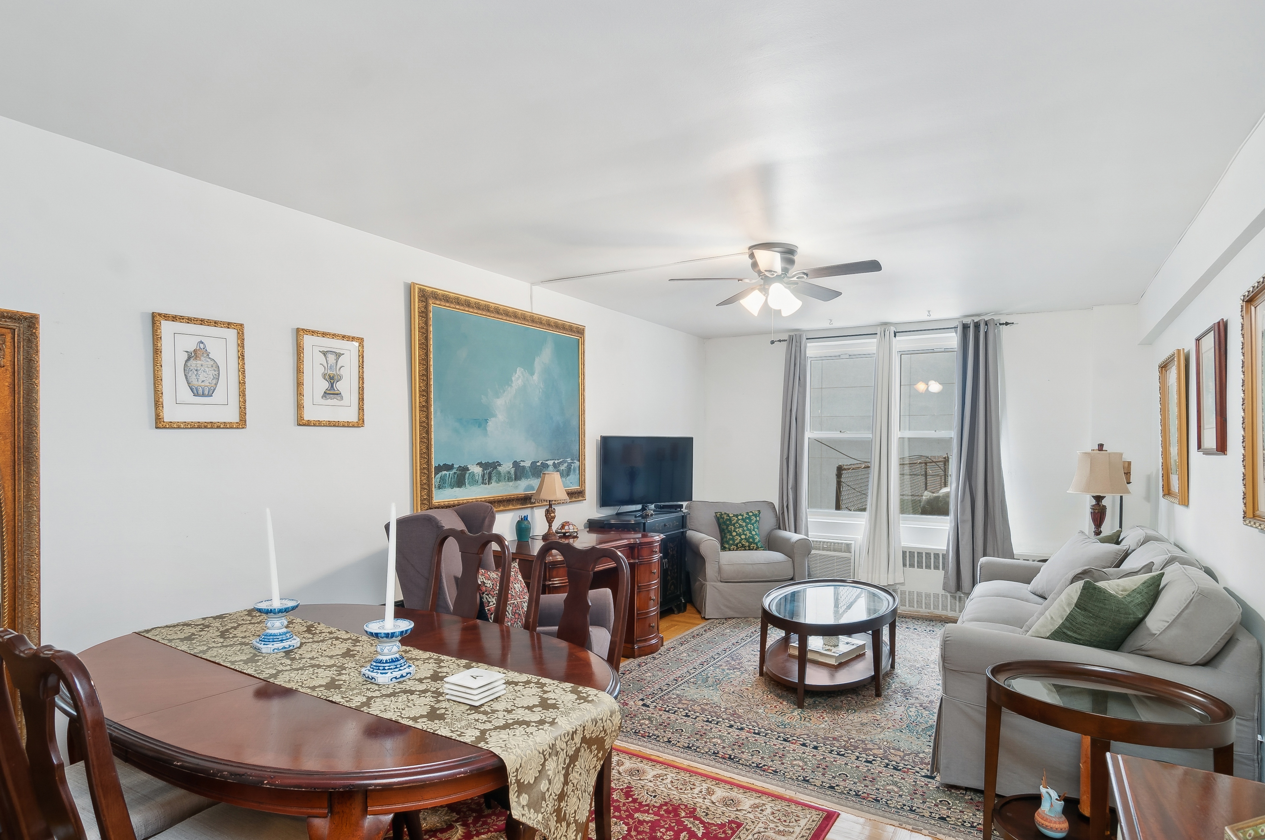 408 West 34th Street, Unit 1F Manhattan, NY 10001 - Photo 2 of 13 a living room with furniture a flat screen tv and a large window