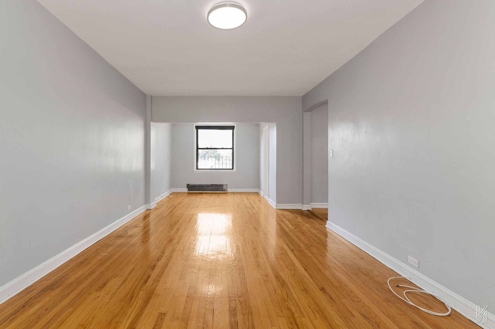 22-20 76th Street, Unit C3 Queens, NY 11370 - Photo 8 of 20 a view of empty room with window and wooden floor