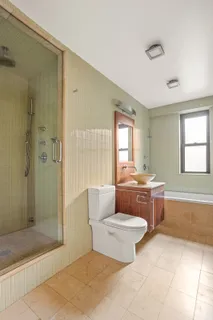 a bathroom with a granite countertop sink a toilet and shower