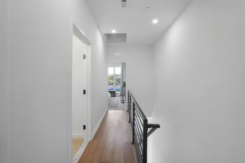 a view of a hallway with wooden floor and entryway