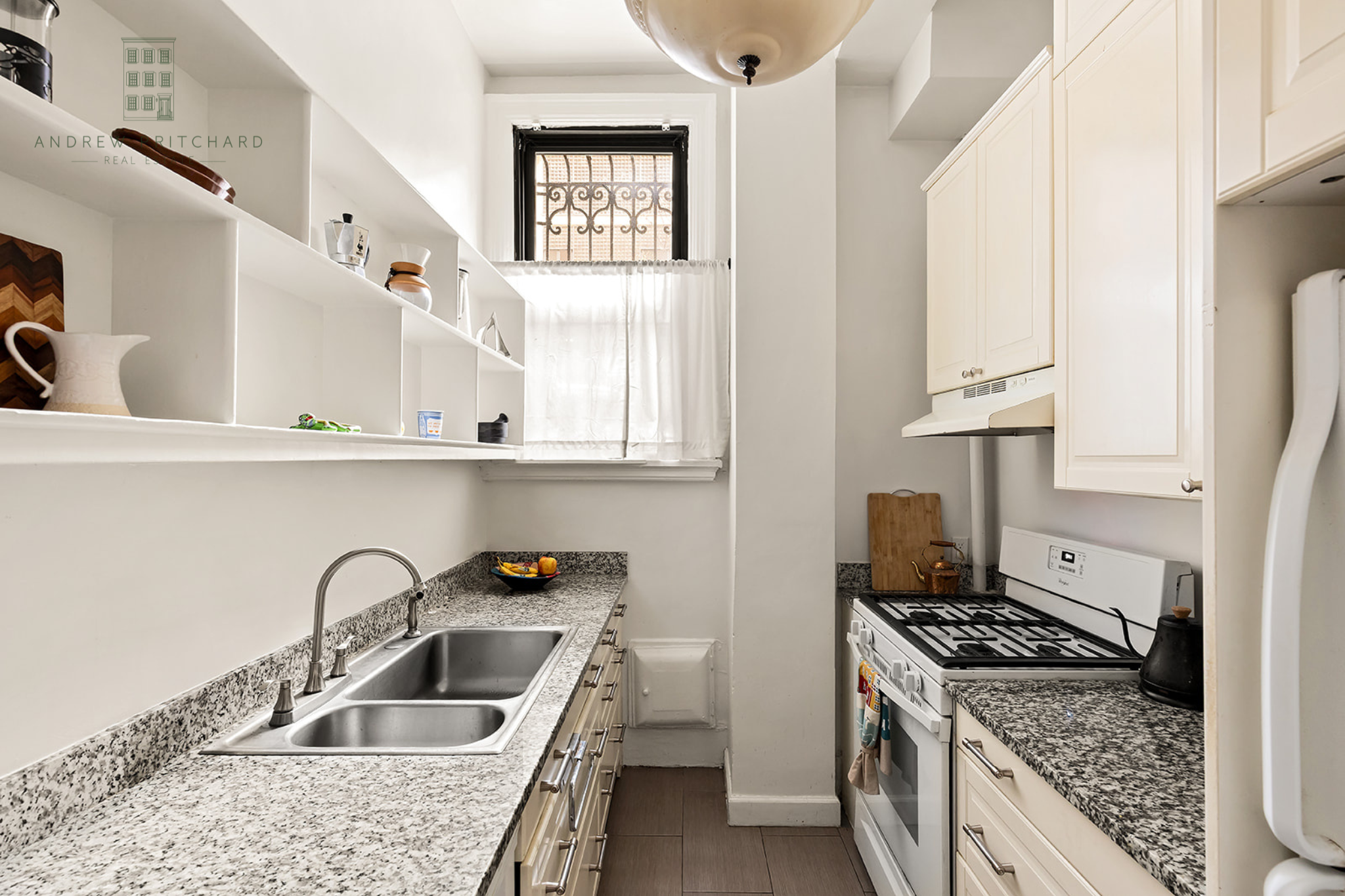 212 East 48th Street, Unit 1D Manhattan, NY 10017 - Photo 8 of 12 a kitchen with white cabinets a sink stove and refrigerator