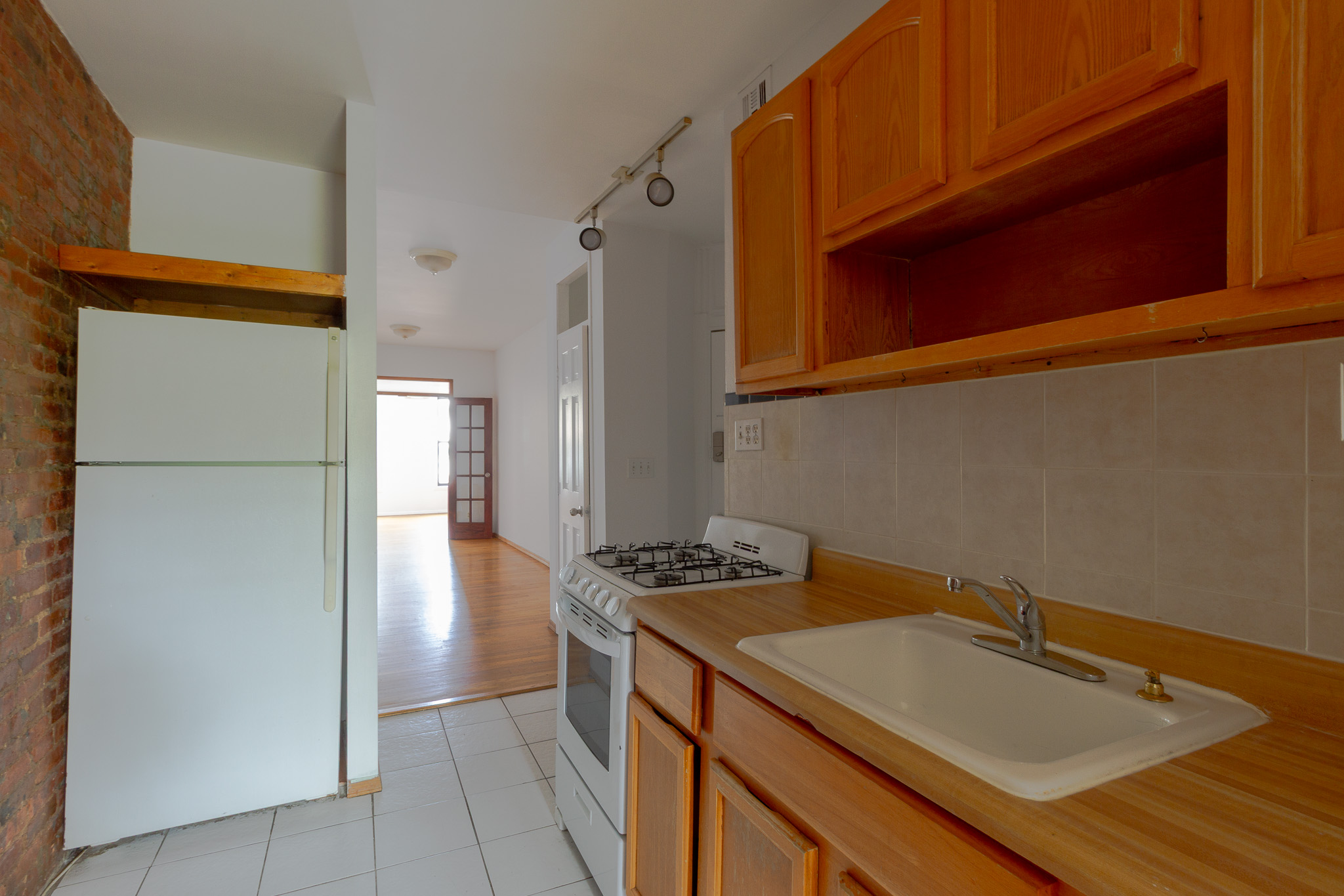 312 Prospect Avenue, Unit 2R Brooklyn, NY 11215 - Photo 7 of 10 a kitchen with a sink a refrigerator and cabinets