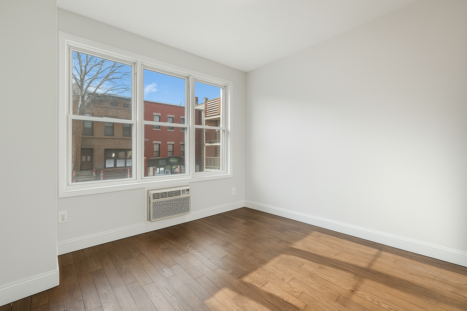 671 Metropolitan Avenue, Unit Undisclosed Brooklyn, NY 11211 - Photo 6 of 13 a view of an empty room with wooden floor and a window