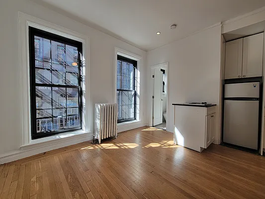 172 5th Avenue, Unit 2F Manhattan, NY 10010 - Photo 2 of 10 a view of an empty room with a fireplace and wooden floor