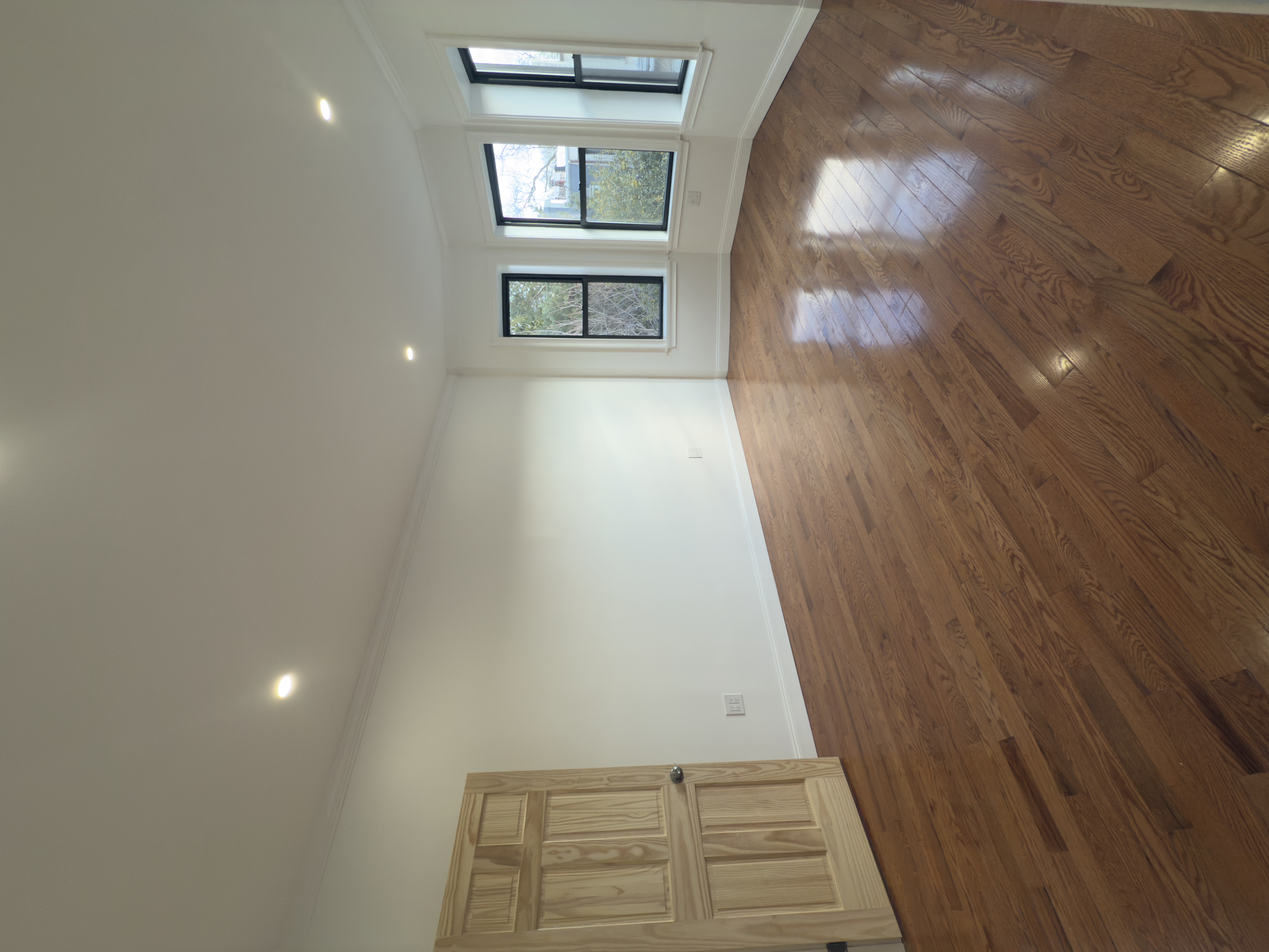 82 74th Street Brooklyn, NY 11209 - Photo 8 of 21 an empty room with wooden floor and windows