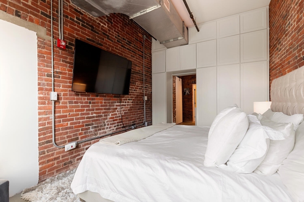 35 Channel Center Street, Unit 402 Boston, MA 02210 - Photo 21 of 35 a bedroom with a bed and a flat screen tv
