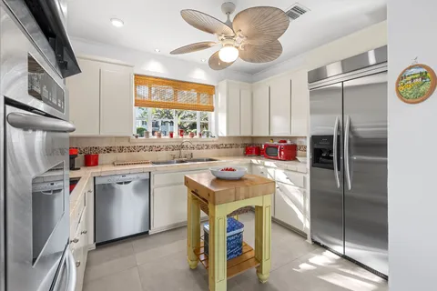 a kitchen with a sink a refrigerator a washer dryer and a dining table