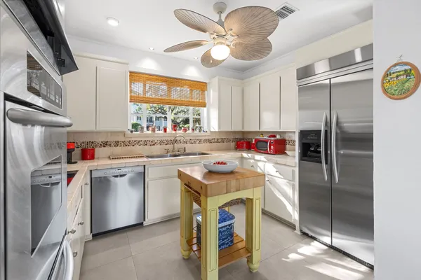 a kitchen with a sink a refrigerator a washer dryer and a dining table