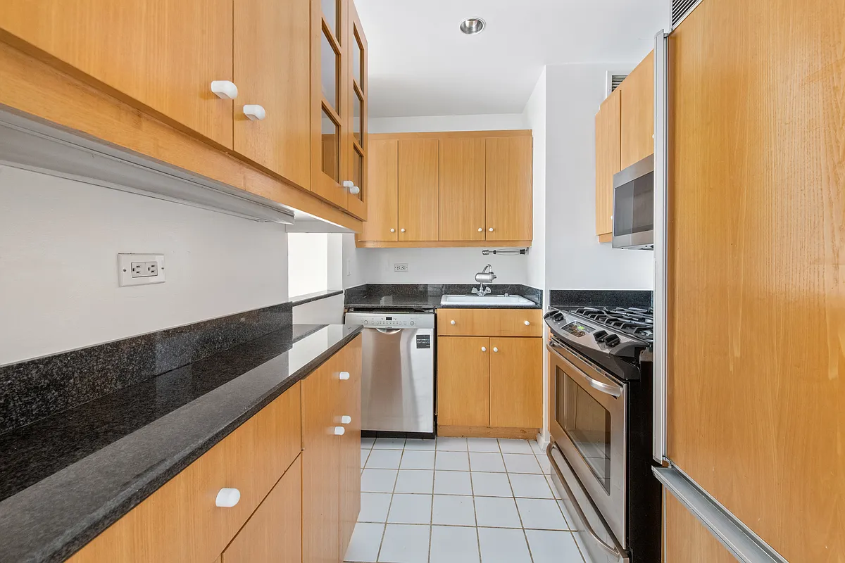 160 West 66th Street, Unit 17E Manhattan, NY 10023 - Photo 3 of 13 a kitchen with stainless steel appliances granite countertop a stove a sink and a refrigerator