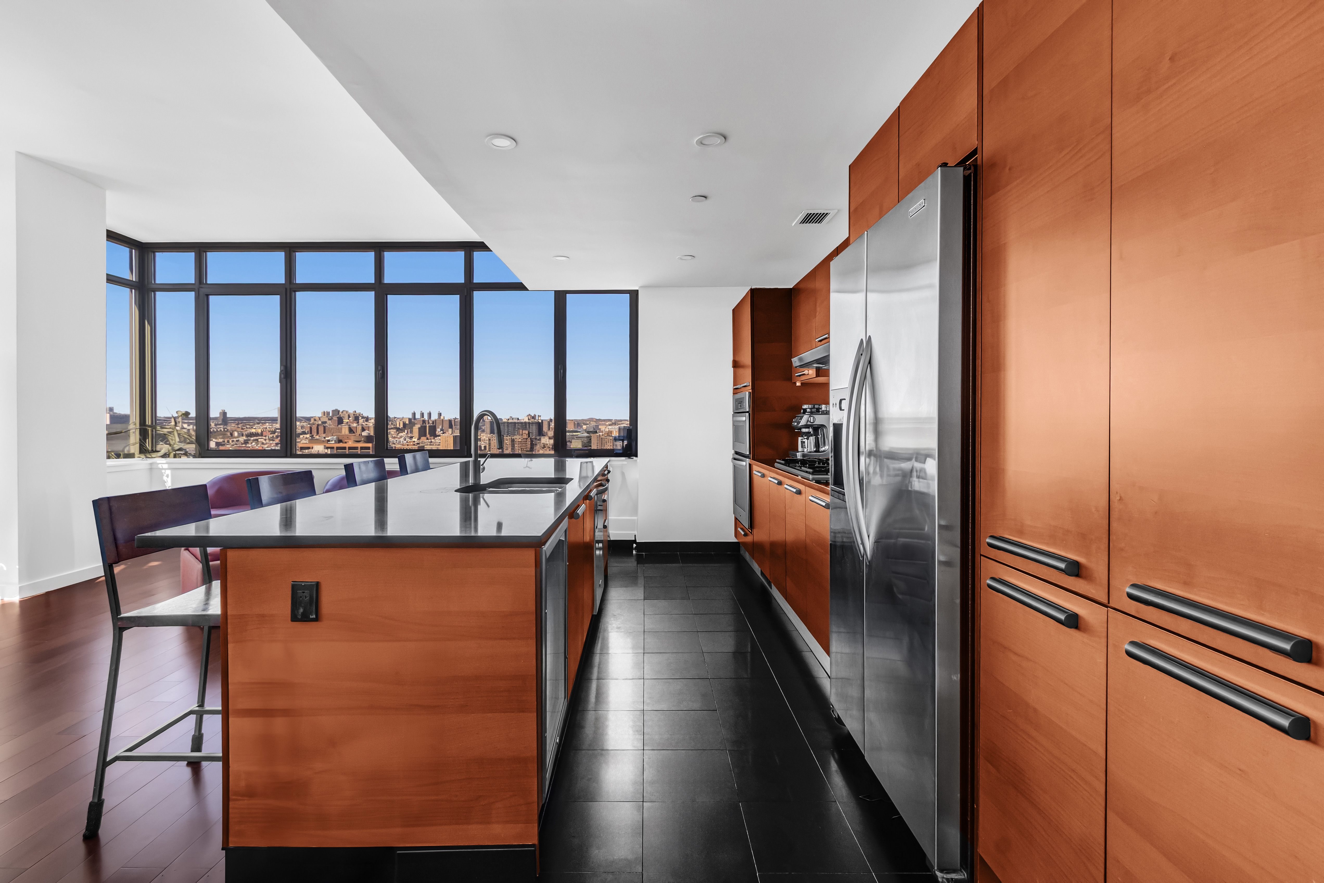 1485 5th Avenue, Unit 24F Manhattan, NY 10035 - Photo 2 of 16 a kitchen with stainless steel appliances granite countertop a refrigerator a stove and a sink with wooden floor