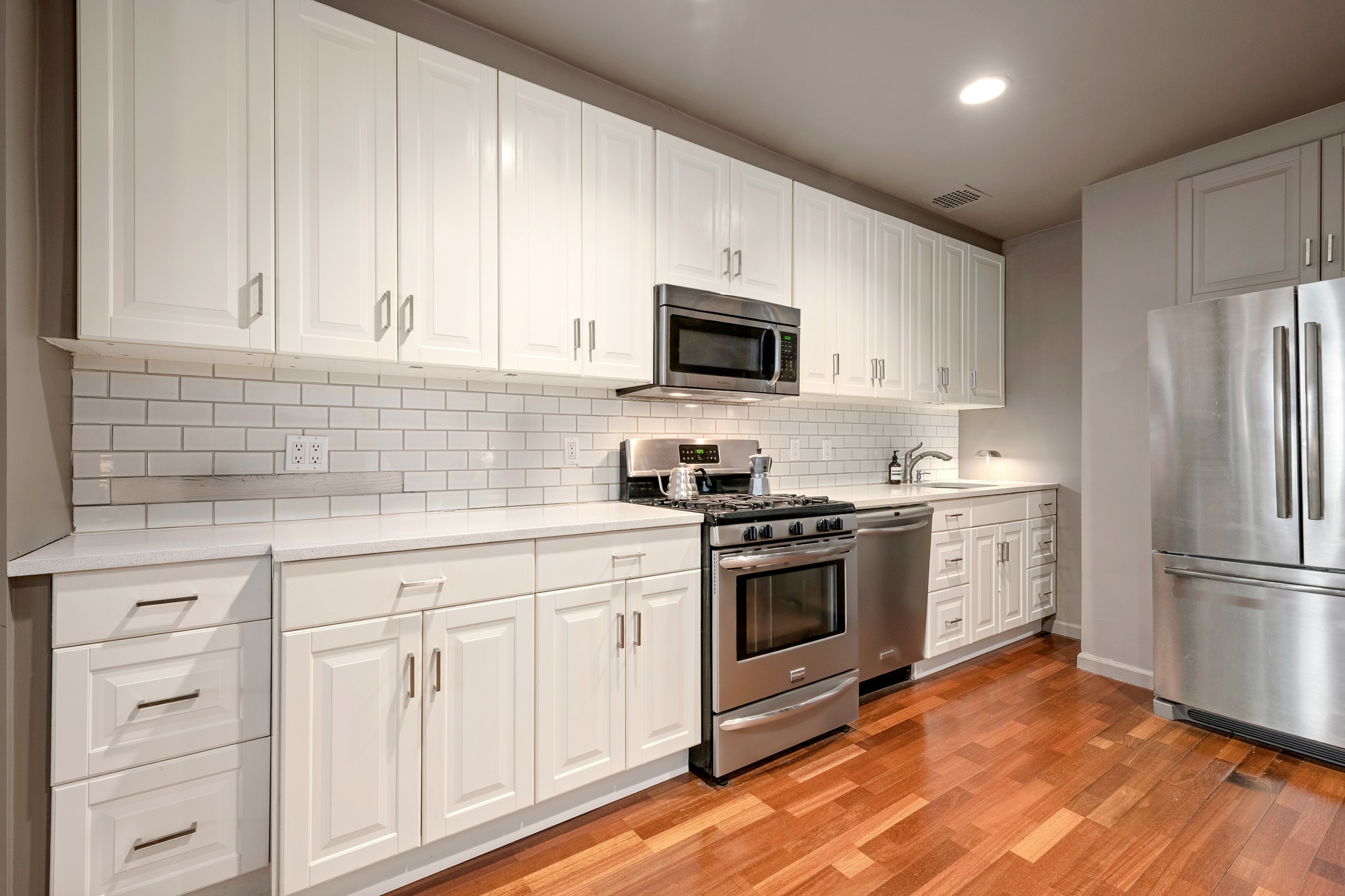 309 West 103rd Street, Unit 3 Manhattan, NY 10025 - Photo 5 of 9 a kitchen with cabinets stainless steel appliances and wooden floor