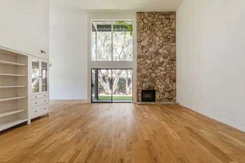an empty room with windows and fireplace
