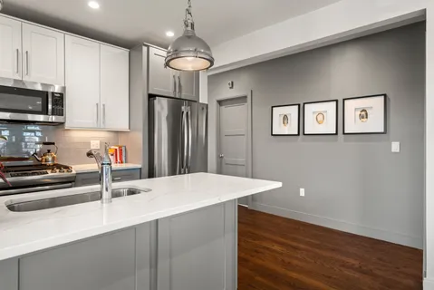 a kitchen with stainless steel appliances granite countertop a sink refrigerator and microwave