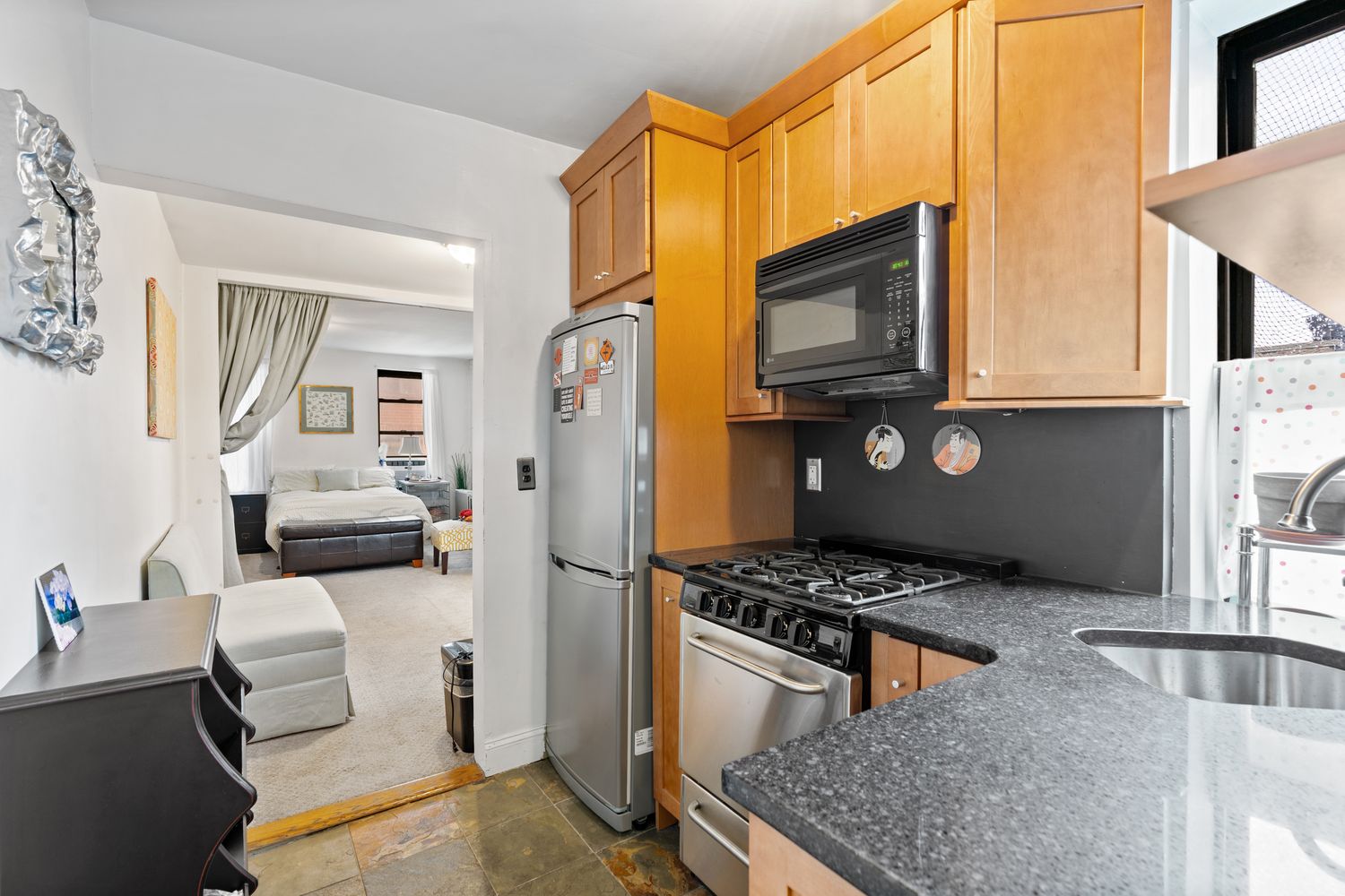 a kitchen with stainless steel appliances granite countertop a stove a refrigerator and a microwave