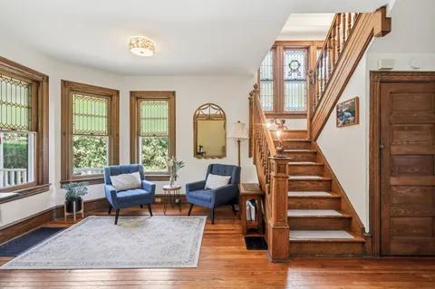a view of entryway a hall with wooden floor and front door