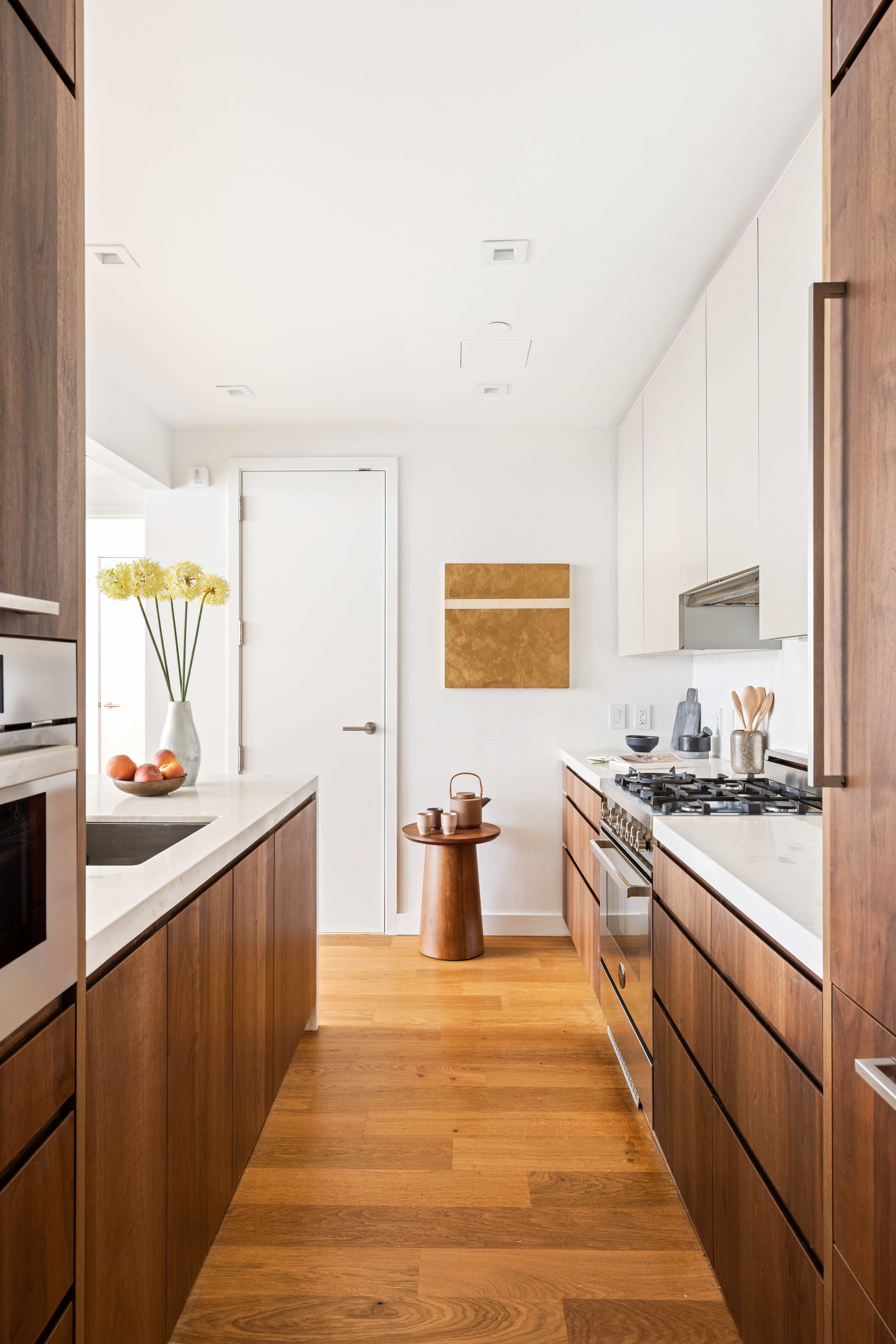 360 East 89th Street, Unit 5D Manhattan, NY 10128 - Photo 6 of 13 a kitchen with a sink and wooden cabinets