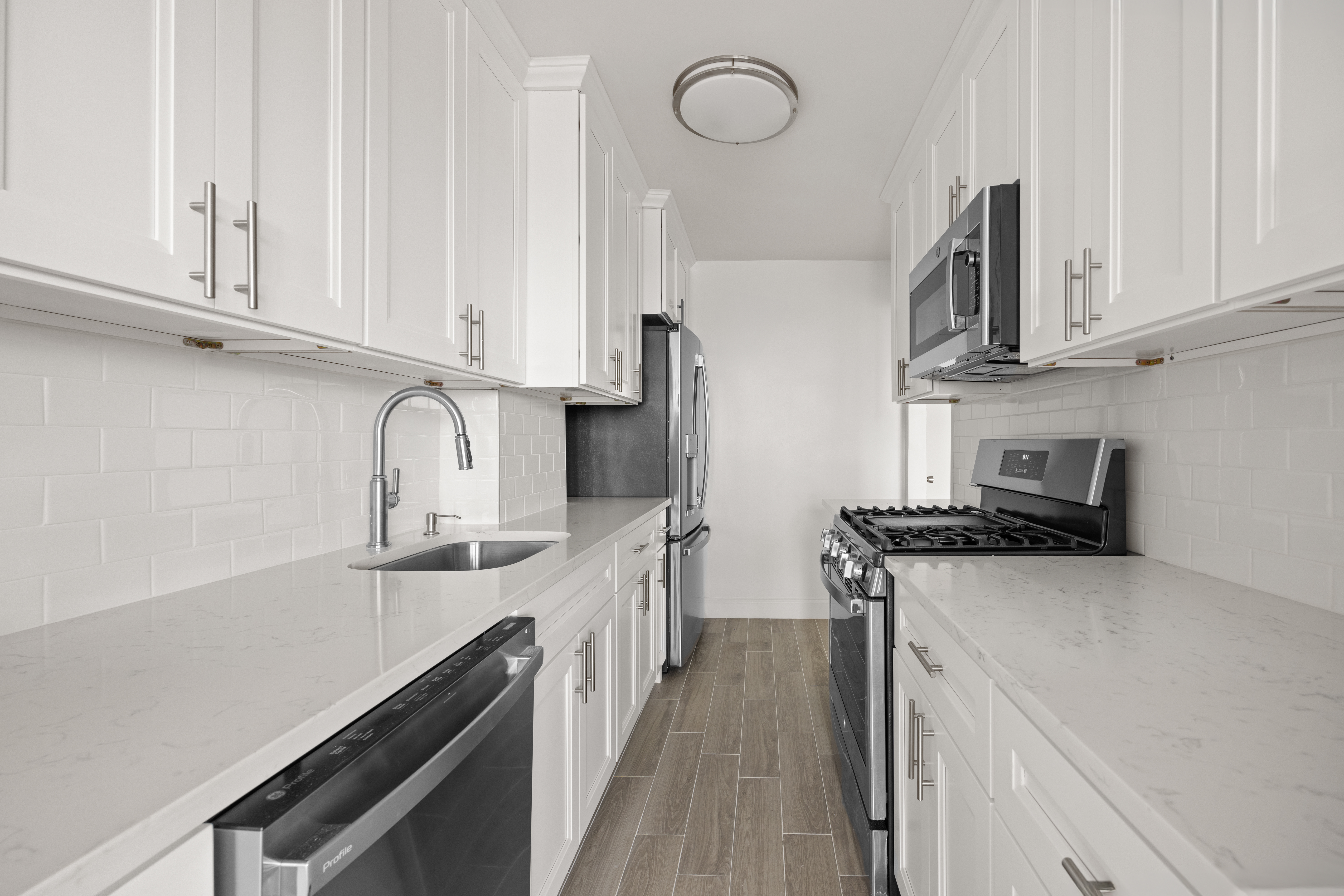 135 Ocean Parkway, Unit 16N Brooklyn, NY 11218 - Photo 8 of 16 a kitchen with stainless steel appliances granite countertop a sink stove and refrigerator