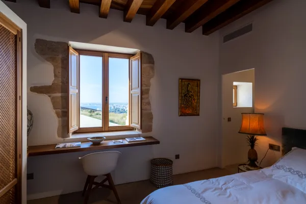 a bedroom with a large bed and a chandelier