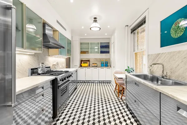 a kitchen with a sink stove top oven and glass door