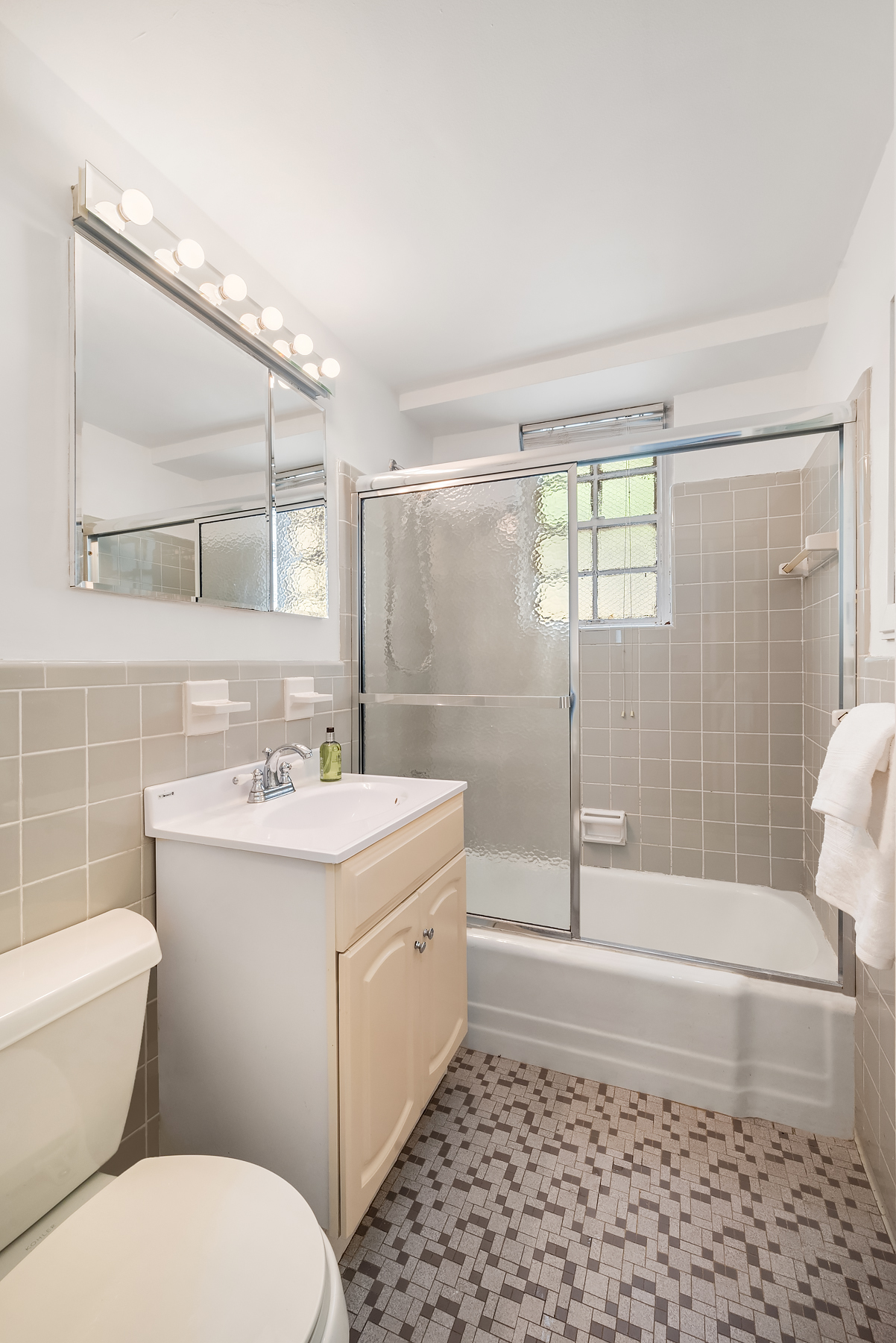 347 East 53rd Street, Unit 9C Manhattan, NY 10022 - Photo 8 of 10 a bathroom with a sink a toilet and shower