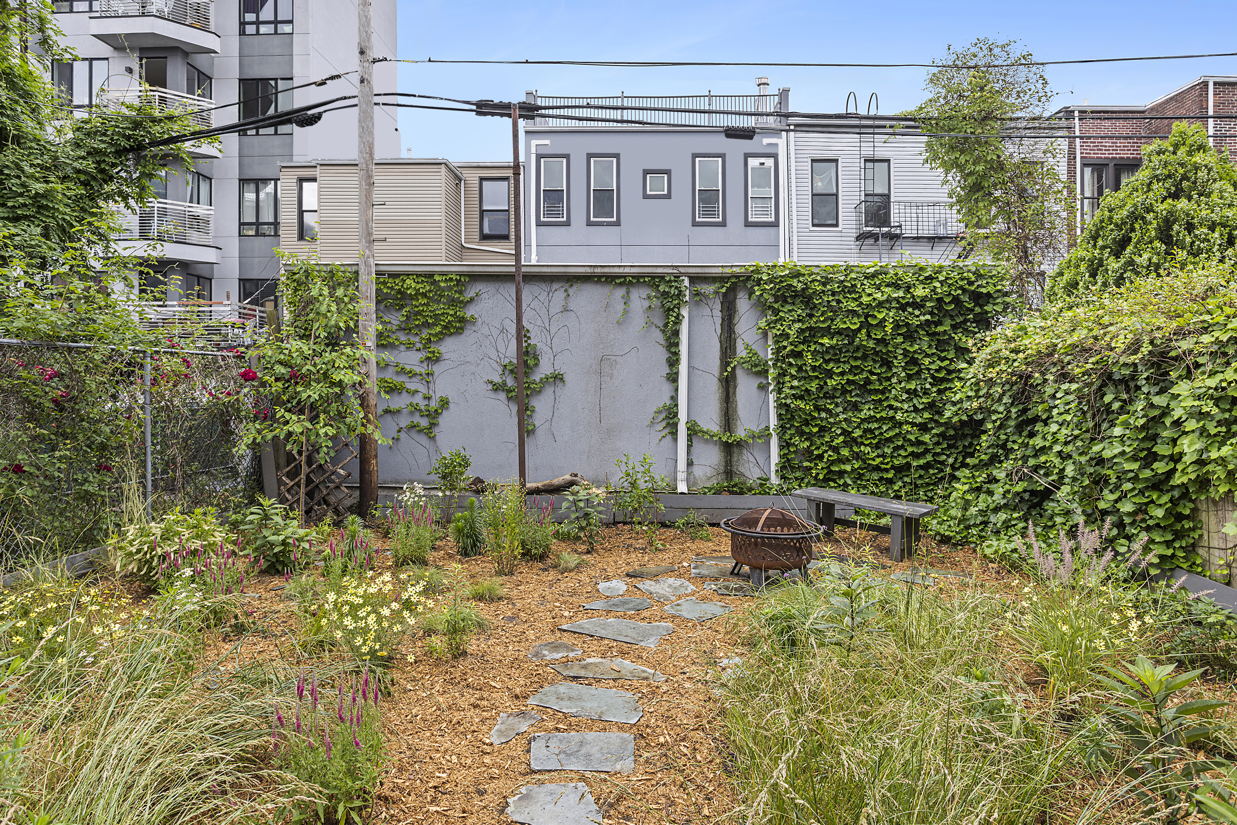 768 Hart Street, Unit 1 Brooklyn, NY 11237 - Photo 16 of 18 a backyard of a house with a yard and plants