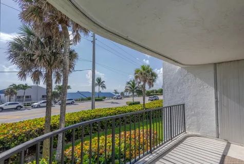 a living room with furniture a large window and kitchen view