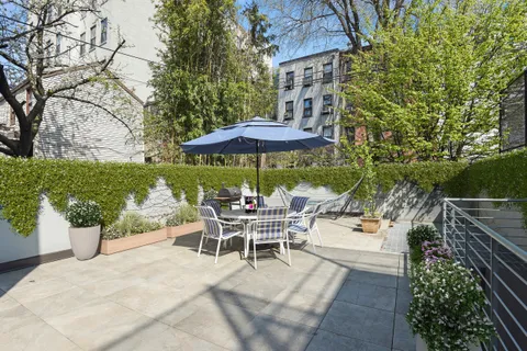 a view of a patio with a table and chairs under an umbrella