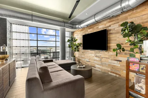 a living room with furniture a flat screen tv and a floor to ceiling window