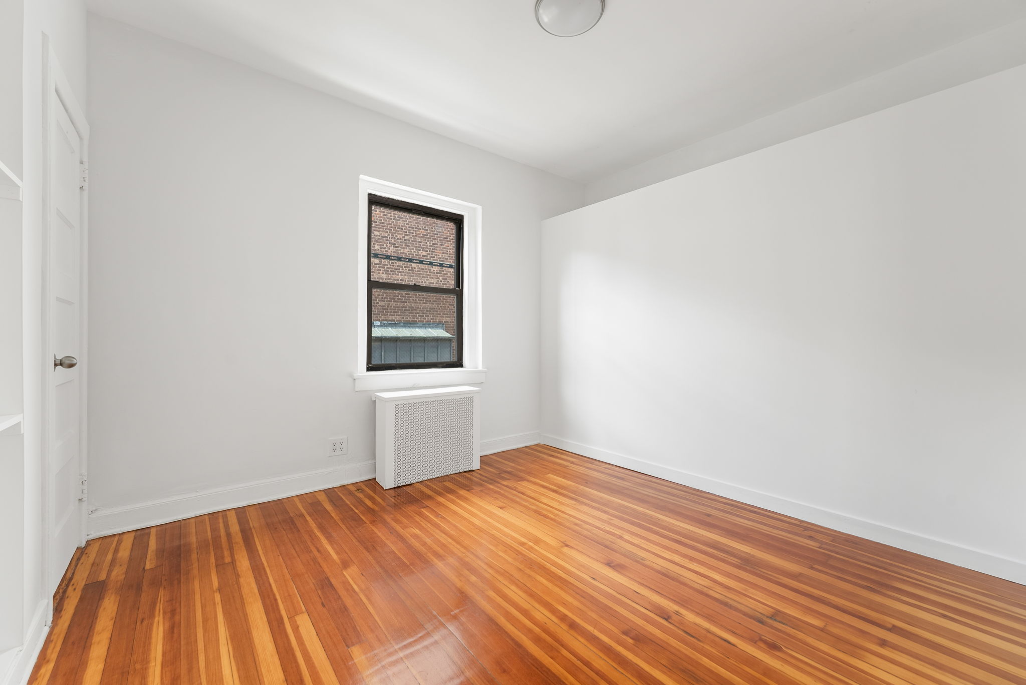 710 Carroll Street Brooklyn, NY 11215 - Photo 5 of 10 a view of empty room with wooden floor and fan