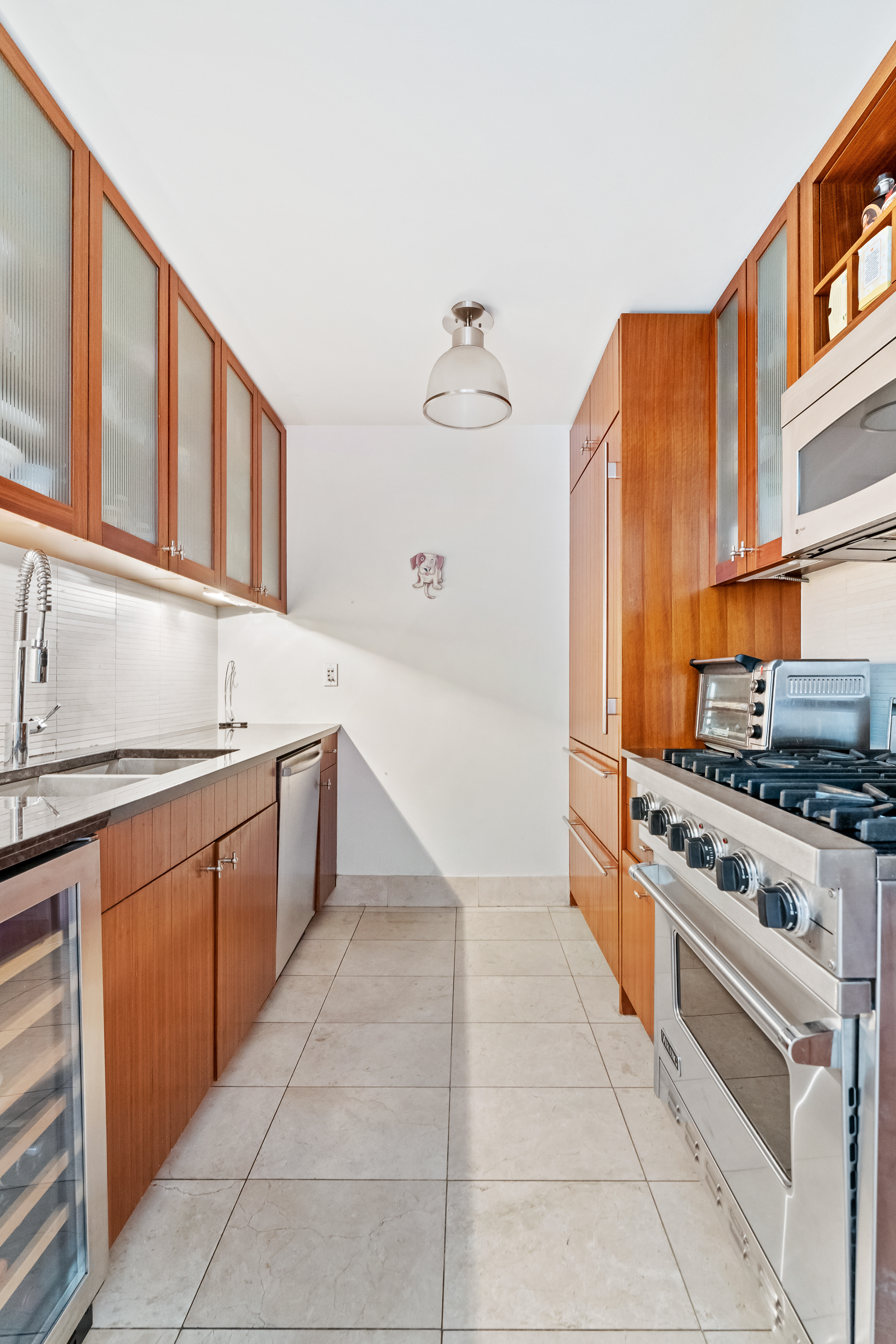 250 East 53rd Street, Unit 903 Manhattan, NY 10022 - Photo 5 of 8 a kitchen with stainless steel appliances granite countertop a stove and a sink