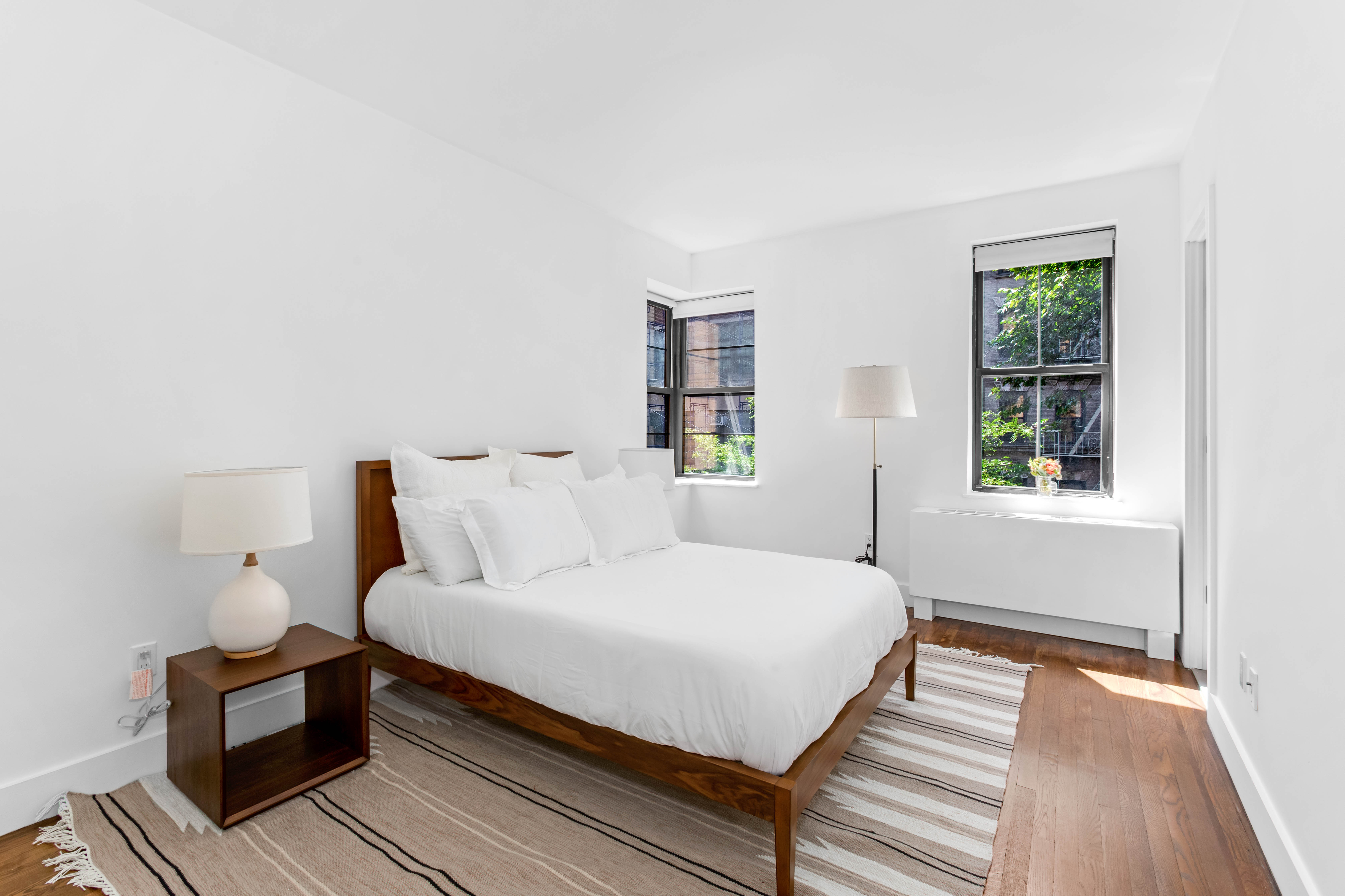 245 West 25th Street, Unit 2A Manhattan, NY 10001 - Photo 3 of 13 a bedroom with a bed and wooden floor