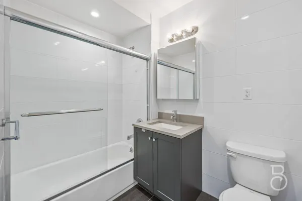 a bathroom with a granite countertop sink toilet and shower